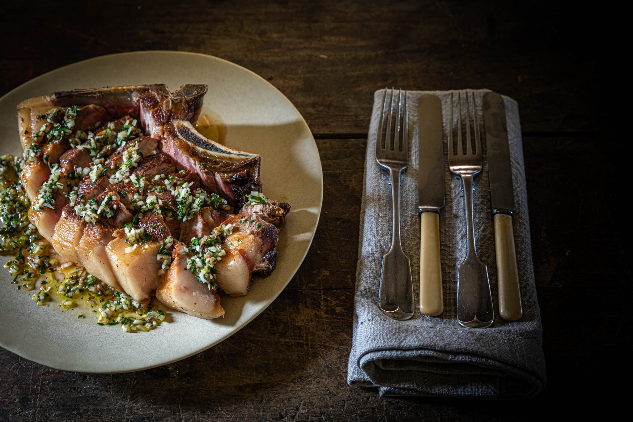 cooked and served dry-aged pork shoulder chop with anchovy dressing