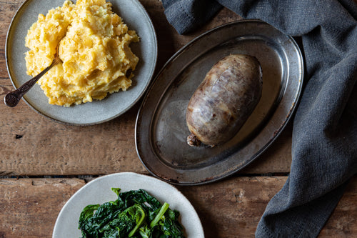 cooked haggis served with neeps, tatties and collard greens